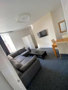 uma sala de estar com um sofá e uma mesa em Newcastle Apartment 2 - Free Parking em Old Walker