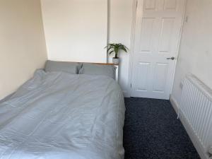 um quarto com uma cama branca e uma planta em Newcastle Apartment 2 - Free Parking em Old Walker