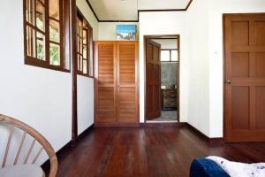 przedpokój domu z drewnianymi podłogami i drzwiami w obiekcie Nongsa Village Peaceful Villa in private beach Resort w mieście Nongsa