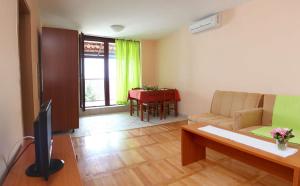 a living room with a couch and a tv and a table at Apartments Unija Duga Uvala in Krnica