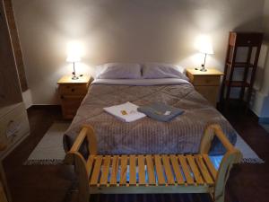 1 dormitorio con 1 cama con banco y 2 lámparas en Cabaña Flor de Cardón-Juella. en Juella