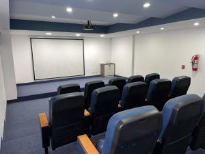 una sala de conferencias con sillas negras y una pantalla blanca en BEAUTIFUL AND COZY SUITE NEAR CAROLINA PARK, en Quito