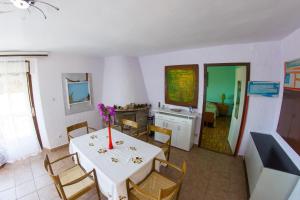 ein Esszimmer mit einem Tisch und einer Blumenvase darauf in der Unterkunft Apartments Stefanovski Paradiso in Veli Lošinj
