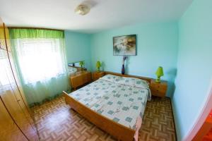 a bedroom with a bed and a blue wall at Apartments Stefanovski Paradiso in Veli Lošinj