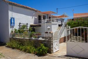 ein Haus mit einer weißen Treppe davor in der Unterkunft Apartments Stefanovski Paradiso in Veli Lošinj