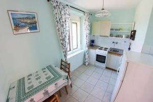 a small kitchen with a table and a stove at Apartments Stefanovski Paradiso in Veli Lošinj +13 photos
