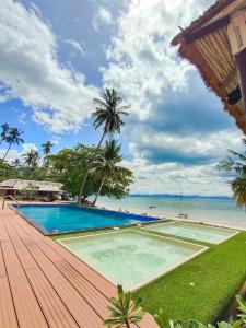 a swimming pool on a wooden deck next to the ocean at Koh Talu Island Resort in Bang Saphan Noi