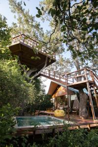 a tree house with a swimming pool and a bridge at Tribe Yala - Luxury Camping in Yala