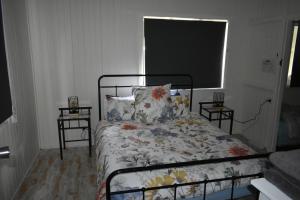 a bedroom with a bed with a floral bedspread at Happy Pig Farm in Stanthorpe