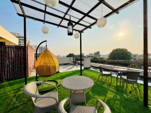 a patio with chairs and tables on a roof at BluO Studio4 Golf Course Road - Gym, Balcony, Lift in Gurgaon