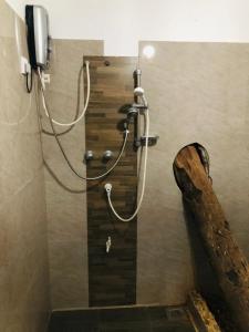 a shower in a bathroom with a wooden wall at Hotel La Felicita in Mirissa