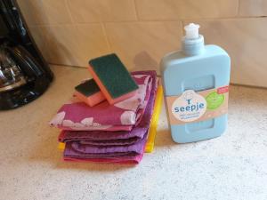 a pile of towels next to a bottle of soap at Repelsteeltje op Terschelling in Formerum +58 photos