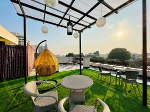 a patio with chairs and tables on a roof at BluO Studio1 Golf Course Road, Gym, Balcony Garden in Gurgaon