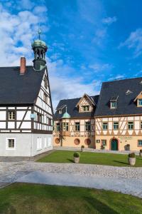 ein großes Gebäude mit einem Uhrturm darüber in der Unterkunft Hotel Saigerhütte in Olbernhau