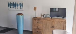 a living room with a tv on a wooden cabinet at Villa Cosy avec piscine privative in Ghisonaccia