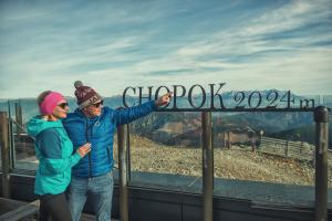 a man and a woman standing next to a sign at Noc na Chopku, Rotunda in Demanovska Dolina