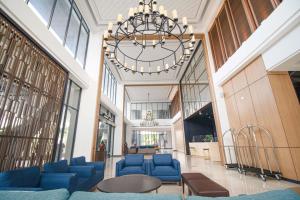 eine große Lobby mit blauen Stühlen und einem Kronleuchter in der Unterkunft Prime Park Hotel & Convention Lombok in Mataram