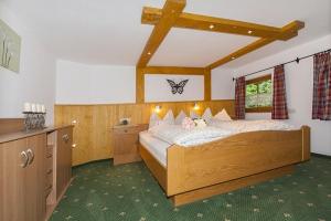 een slaapkamer met een groot houten bed in een kamer bij Kaltbachlehen Ferienwohnungen in Ramsau