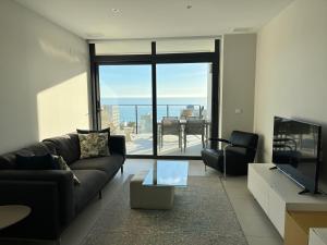 a living room with a couch and a television at Sea View Apartment Arenal Beach Calpe in Calpe