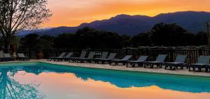 a group of lounge chairs next to a swimming pool at Camping Porto Vecchio in Porto-Vecchio