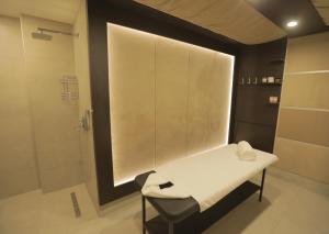 uma casa de banho com um chuveiro e um banco com uma toalha em Dave Hotel Yerevan em Yerevan