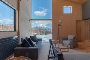 a living room with a view of a snow covered mountain at Foxwood E by H2 Life in Niseko