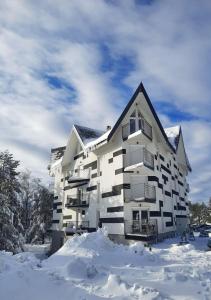 um edifício de apartamentos branco com neve à volta em Triangle studio 4 Divcibare em Divčibare