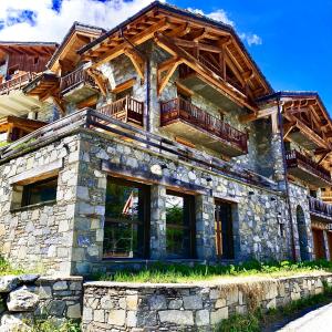 a large stone house with a wooden roof at Chalet Eden Roc in Tignes