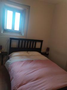 1 cama en un dormitorio con ventana en Ca La Marutxi, en Cantallops