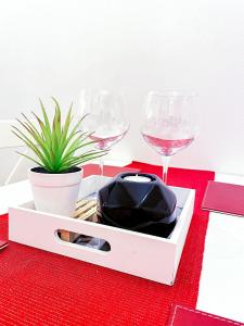 a red table with two wine glasses and a plant at Apartmán Rajecké Teplice in Žilina