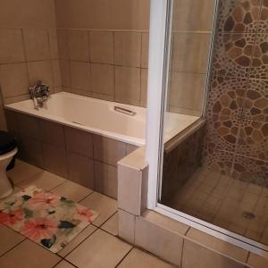 a bathroom with a bath tub and a toilet at Monte Roza Guest House in De Doorns +20 photos