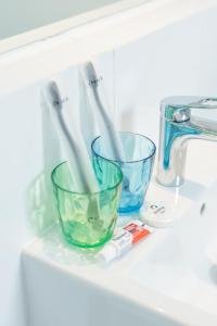 two glass bowls sitting on a shelf next to a sink at Joylive BSD City in Tangerang