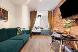 a living room with a green couch and a brick wall at Bob W Tallinn City Centre - Avangard in Tallinn