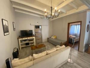a living room with a couch and a tv at Alamo - Casa pet friendly in Olavarría