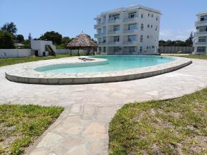 a swimming pool with a gazebo and a building at HavenHouse Kijani - 1 Bedroom Beach Apartment with Swimming Pool in Malindi