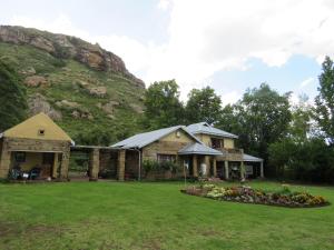 uma casa com uma montanha ao fundo em His Vessel Guesthouse Clarens FS em Clarens