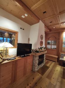 a living room with a television and a fireplace at Hotel Milano in Piazzatorre