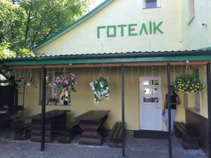 Eine Frau steht vor einem Café in der Unterkunft Готелік in Drohobytsch