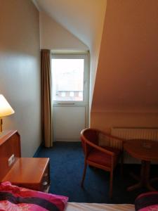 ein Hotelzimmer mit einem Tisch und einem Fenster in der Unterkunft apartment Lampertheim in Lampertheim