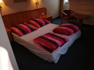 a bed with red and black pillows on it at apartment Lampertheim in Lampertheim