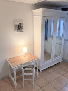 Zimmer mit einem Tisch, einem Stuhl und einem Schrank in der Unterkunft Appartement "Jardins" in Pesmes