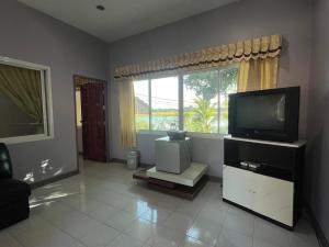 a living room with a television and a window at ทุ่งดินดำ Farm Stay in Ban Kho Wang +65 photos