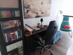 a office with a desk and a chair and a book shelf at Casa Rural El Palomar in El Pedroso