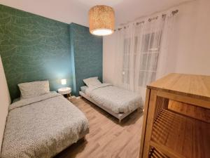 niewielka sypialnia z 2 łóżkami i stołem w obiekcie ***Suite Régence * 5min Disney & Shopping * NEW*** w mieście Serris