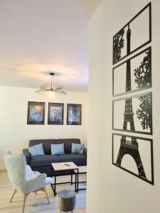 a living room with a couch and a picture of the eiffel tower at ***Suite Régence * 5min Disney & Shopping * NEW*** in Serris