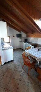 a room with a table and a kitchen with a table and chairs at Mansarde in Cornaiano