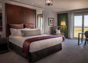 a hotel room with a large bed and a balcony at Old Course Hotel St Andrews in St. Andrews