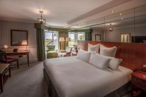 a hotel room with a large bed and a desk at Old Course Hotel St Andrews in St. Andrews