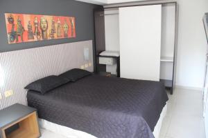 Un dormitorio con una cama con un edredón negro. en Marinas Flat Largo de Tambaú, en João Pessoa