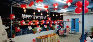 una habitación con globos rojos y blancos y un signo de feliz cumpleaños en Hotel Bharatpur Palace, en Pushkar